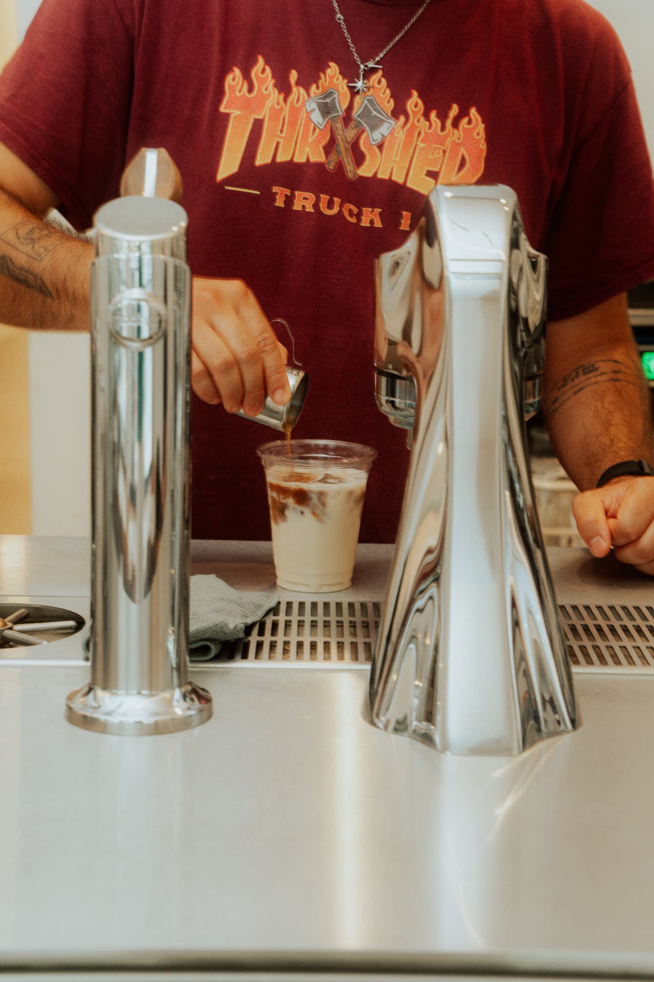 Barista mit Iced Coffee an der Theke