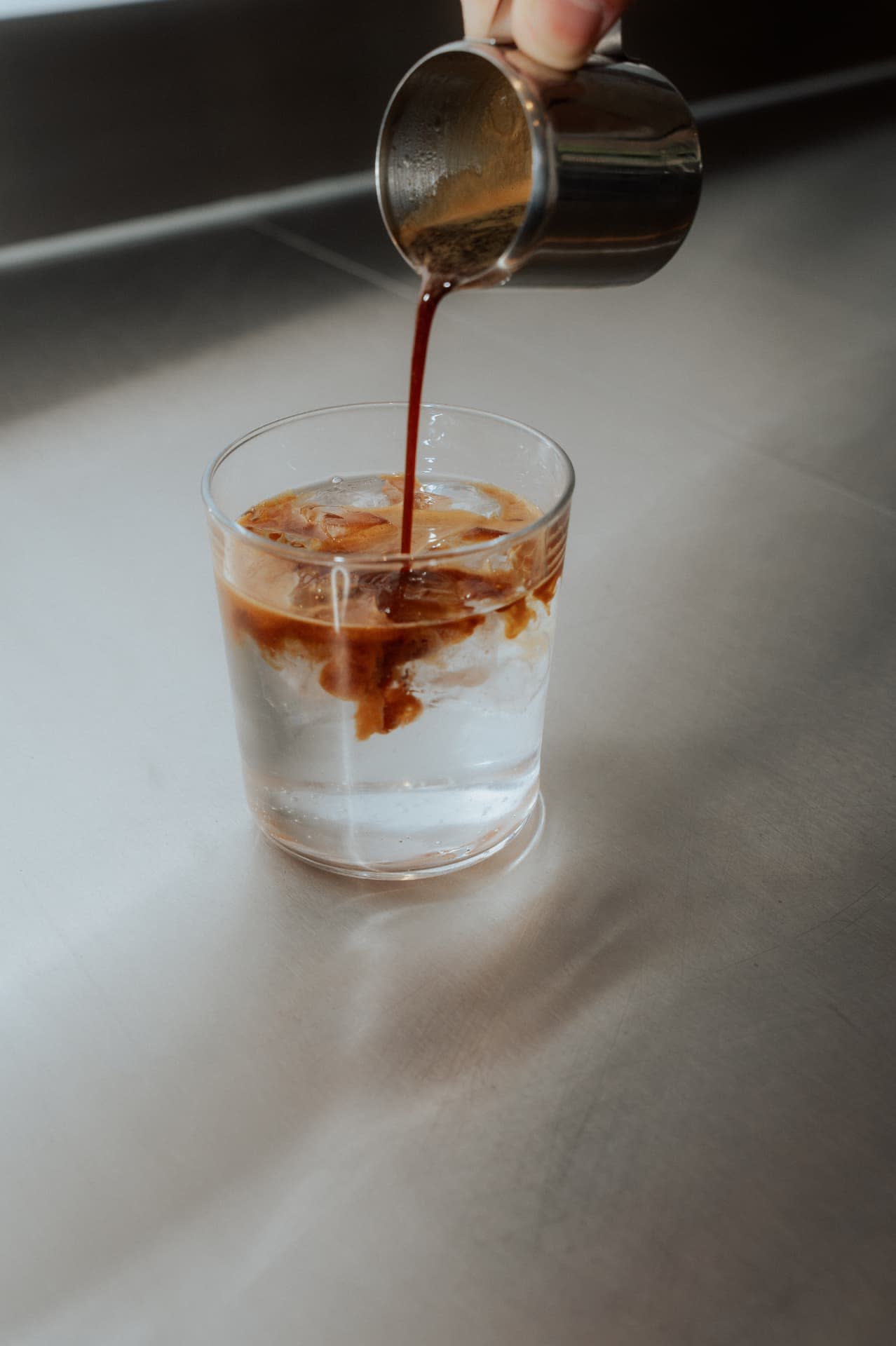 Espresso wird in Eiswasser gegossen